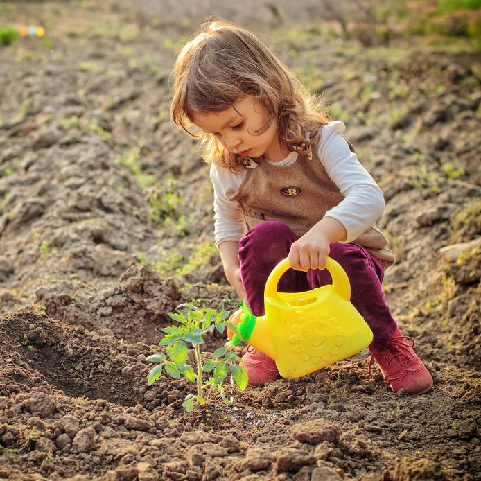 child with watering can